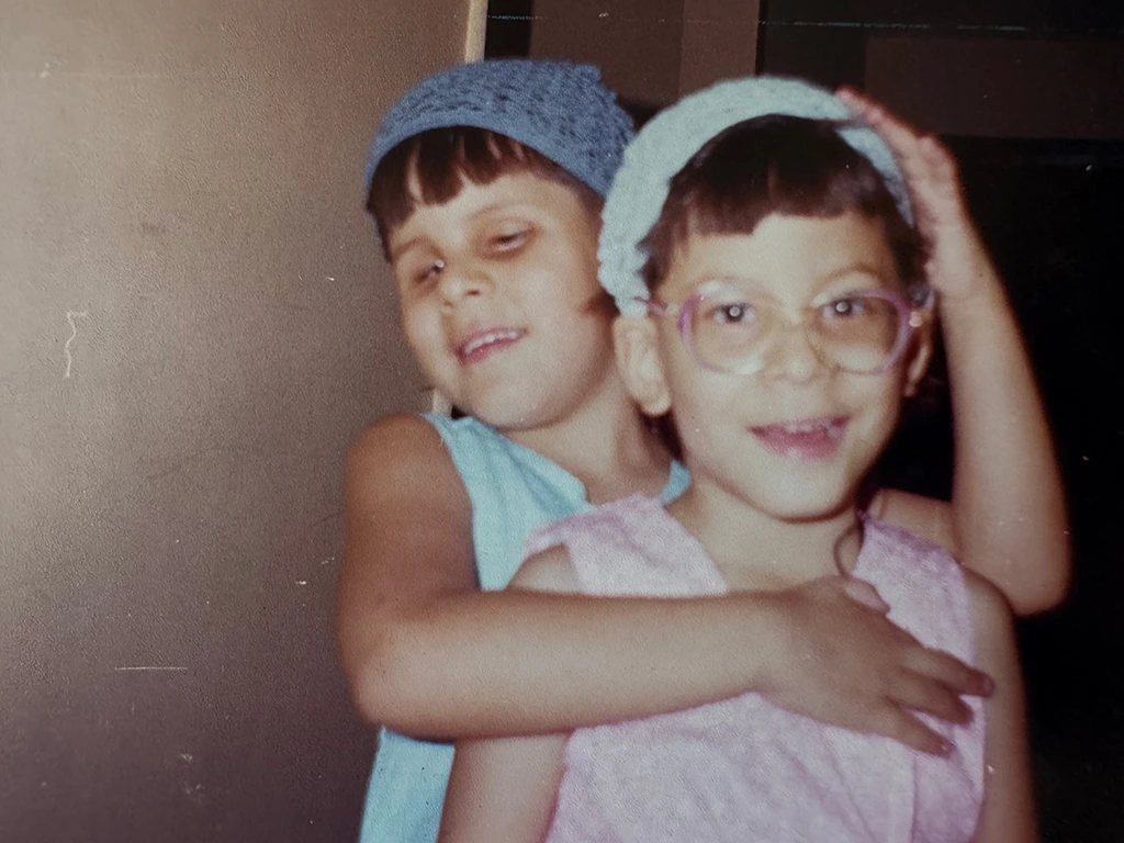 María Paula abrazando a su hermana cuando eran niñas.
              