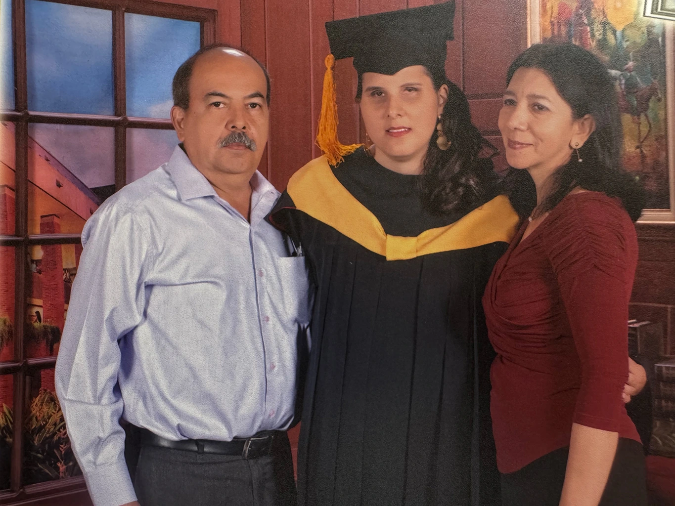 Foto de la graduación de María Paula, está acompañada de sus padres.