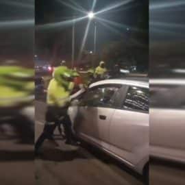 Policía rompe con un bolillo el vidrio del carro de un conductor de Uber
